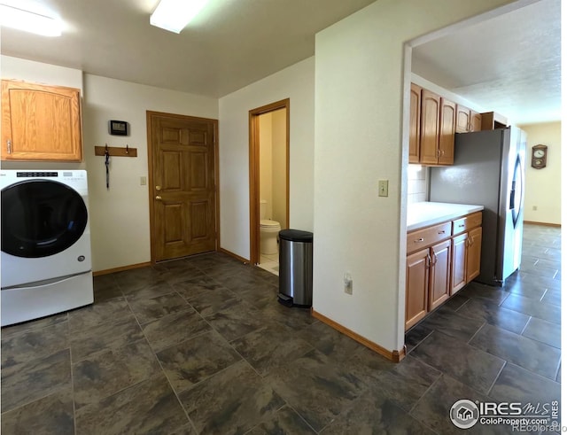 laundry area featuring cabinet space, washer / clothes dryer, and baseboards