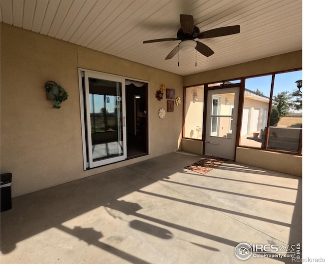 unfurnished sunroom with a ceiling fan