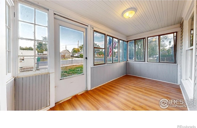 unfurnished sunroom featuring radiator and plenty of natural light