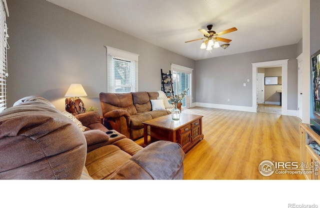 living room featuring light wood-type flooring and ceiling fan