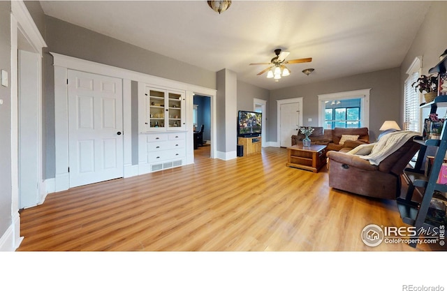 living room with light hardwood / wood-style floors and ceiling fan