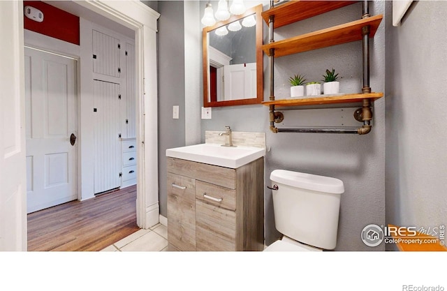 bathroom featuring vanity, toilet, and hardwood / wood-style floors