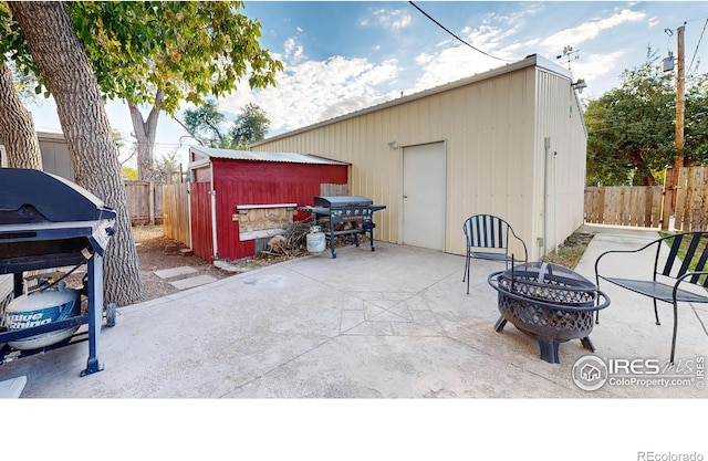 view of patio / terrace with a storage unit, a grill, and a fire pit