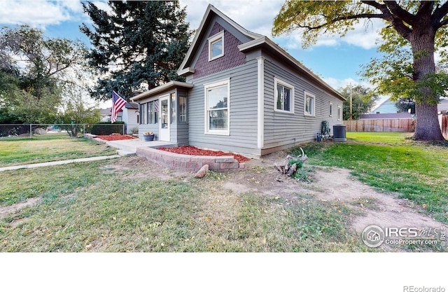 view of home's exterior featuring cooling unit and a yard