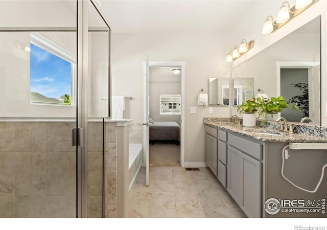 bathroom with a shower with door and vanity