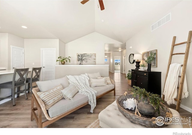 living room with hardwood / wood-style flooring, ceiling fan, and lofted ceiling