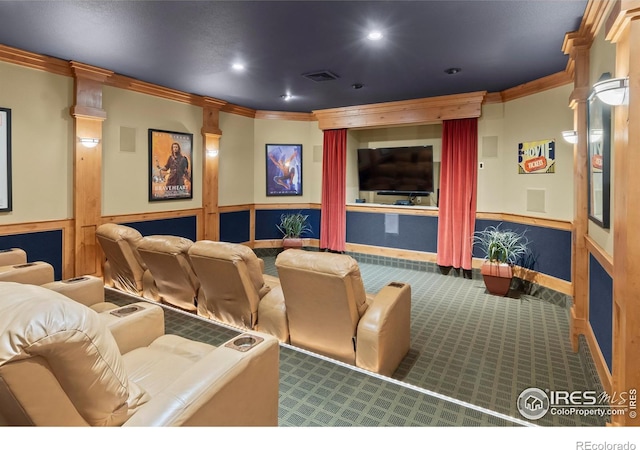 carpeted home theater with ornate columns and crown molding