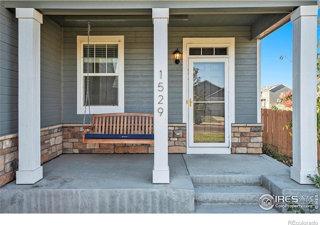 view of exterior entry featuring covered porch