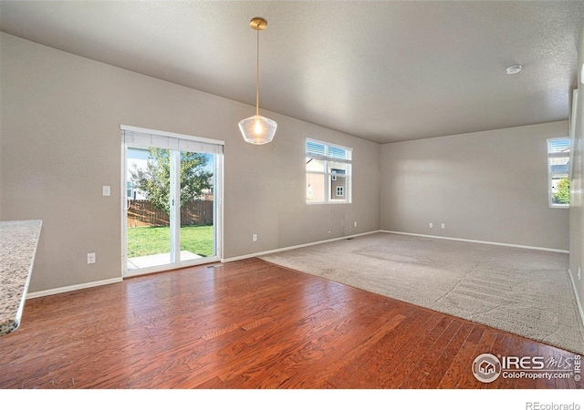 unfurnished room featuring hardwood / wood-style floors, a textured ceiling, and a healthy amount of sunlight