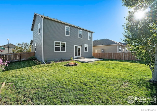 rear view of house featuring a yard, a patio, and an outdoor fire pit