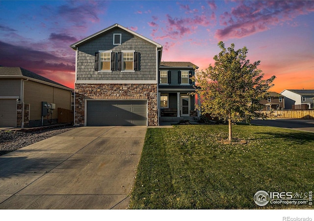 front facade featuring a garage and a lawn