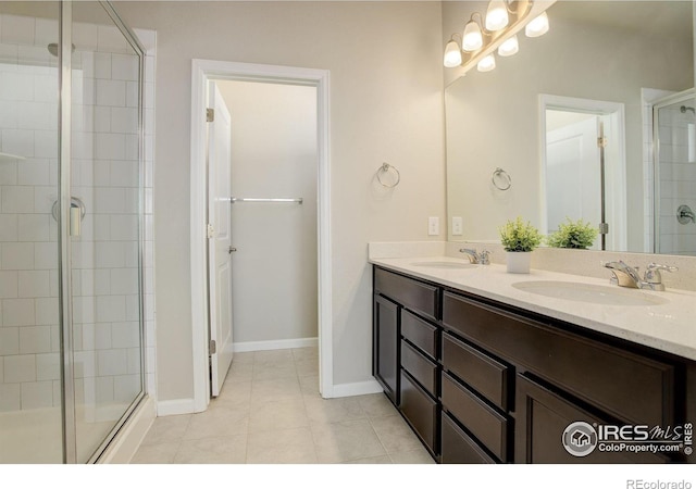 bathroom with a shower with door, vanity, and tile patterned flooring