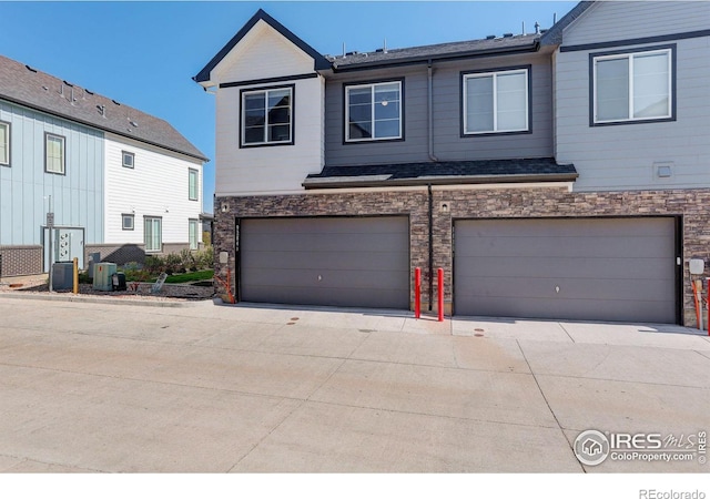 view of property with a garage and central AC unit