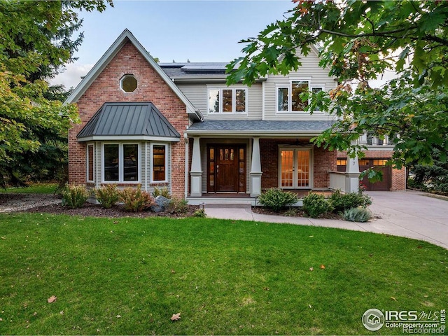 view of front of property with solar panels, a front lawn, and a garage