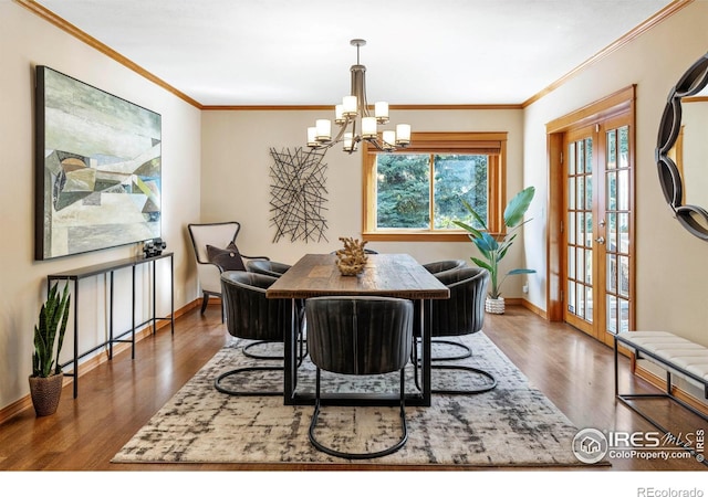 dining room featuring ornamental molding, dark wood-type flooring, an inviting chandelier, and french doors