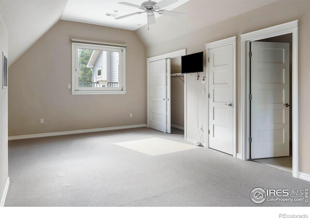 unfurnished bedroom featuring ceiling fan, light carpet, and vaulted ceiling