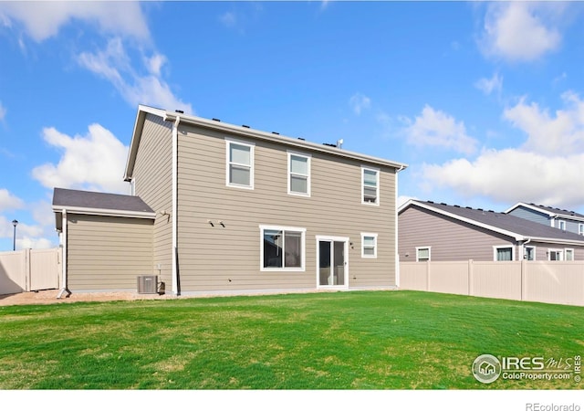 rear view of house with a yard and central air condition unit