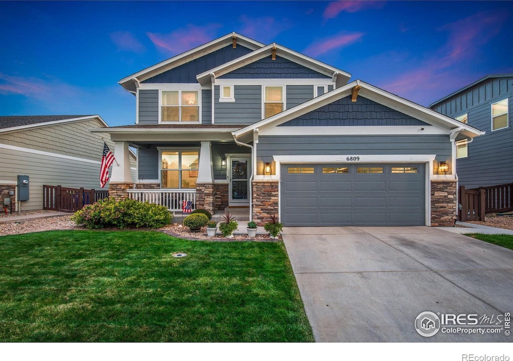 craftsman-style house featuring a garage, a lawn, and covered porch