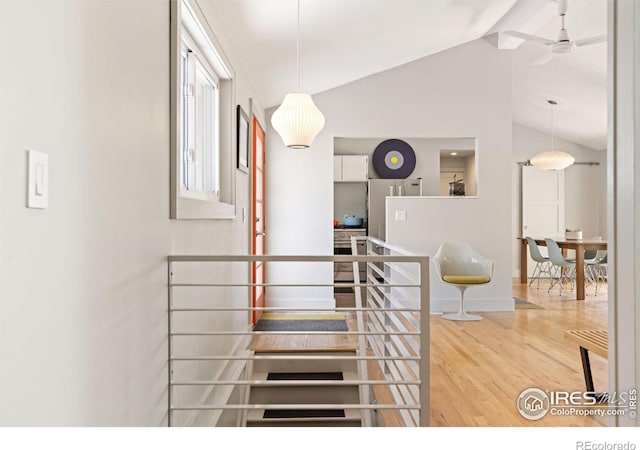 stairway with ceiling fan, lofted ceiling, and hardwood / wood-style flooring