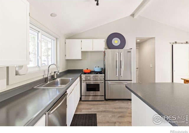 kitchen featuring light wood-type flooring, vaulted ceiling with beams, sink, white cabinetry, and premium appliances