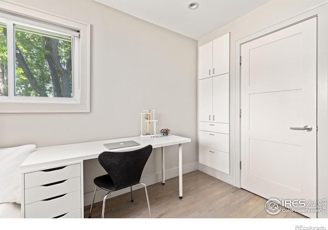 office area with built in desk and light hardwood / wood-style flooring