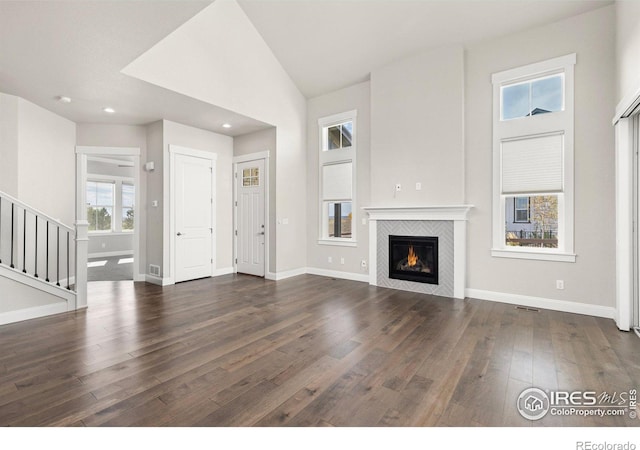 unfurnished living room with a fireplace, dark hardwood / wood-style floors, and high vaulted ceiling