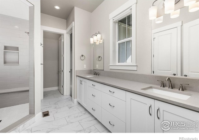 bathroom with vanity and a tile shower