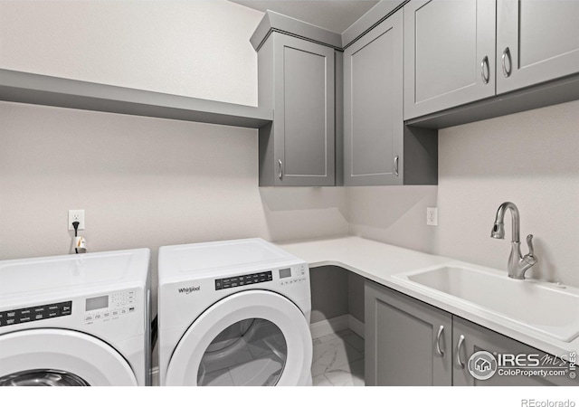 washroom with cabinets, sink, and washing machine and dryer