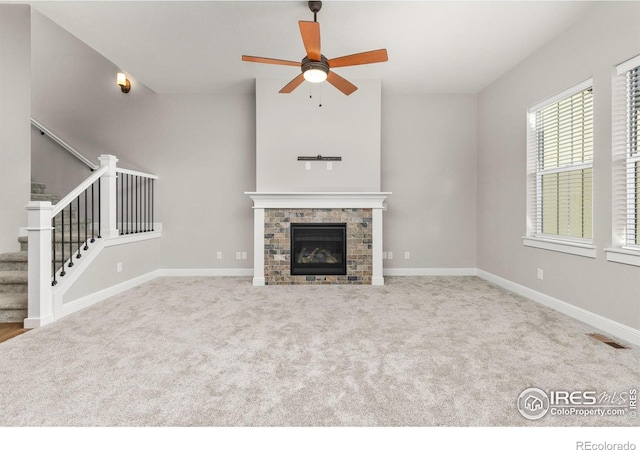 unfurnished living room with light carpet, a fireplace, and ceiling fan