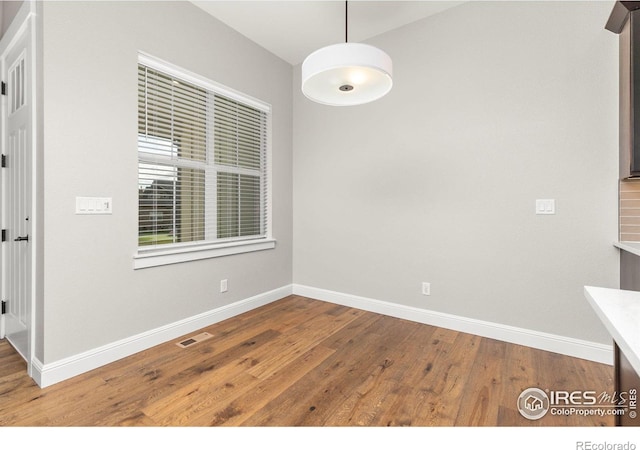 unfurnished dining area featuring hardwood / wood-style floors