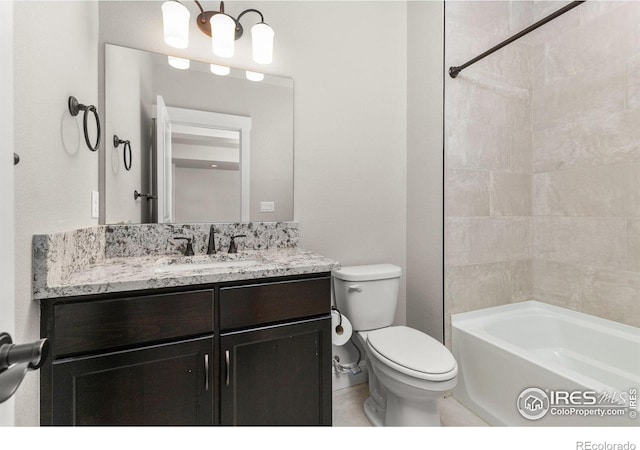 full bathroom featuring toilet, tiled shower / bath combo, and vanity