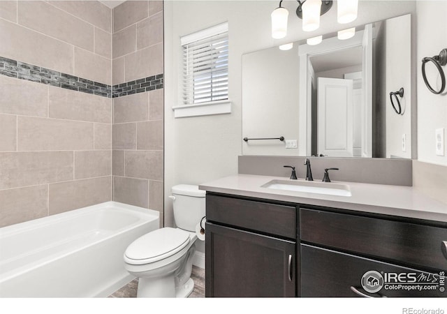 full bathroom with vanity, tiled shower / bath combo, and toilet