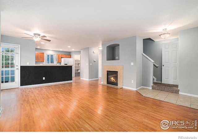 unfurnished living room featuring light wood-type flooring and ceiling fan