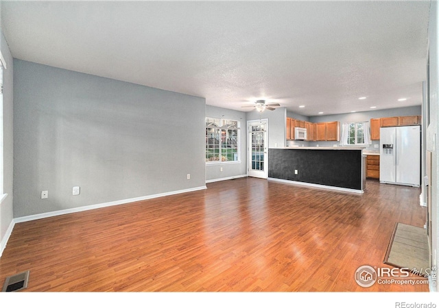 unfurnished living room featuring a textured ceiling and light wood-type flooring