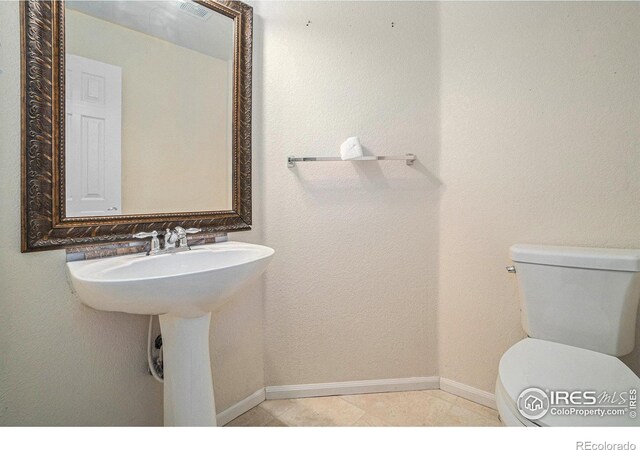 bathroom featuring toilet and tile patterned floors