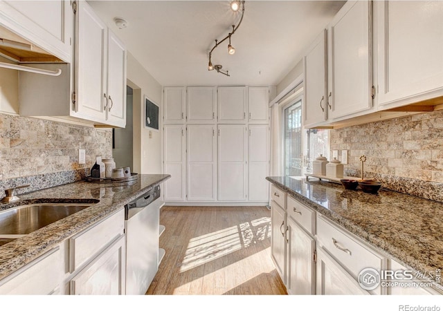 kitchen featuring light hardwood / wood-style floors, light stone countertops, stainless steel dishwasher, and white cabinets