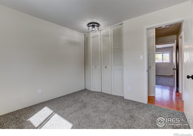 unfurnished bedroom with a closet and wood-type flooring