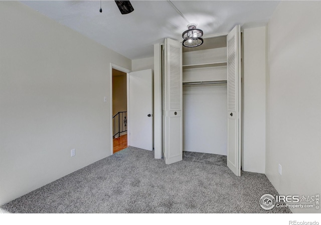 unfurnished bedroom with a closet, ceiling fan, and carpet floors