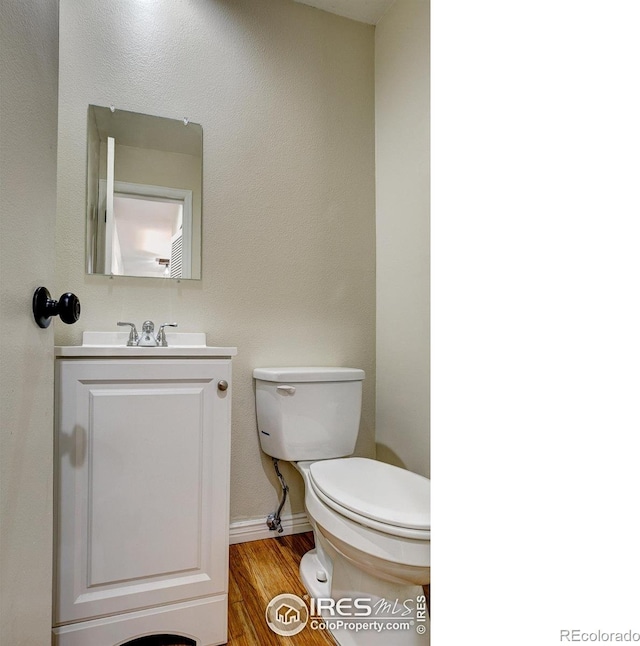 bathroom featuring vanity, hardwood / wood-style flooring, and toilet