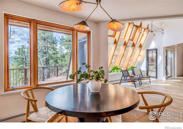 dining space with light hardwood / wood-style flooring and an inviting chandelier