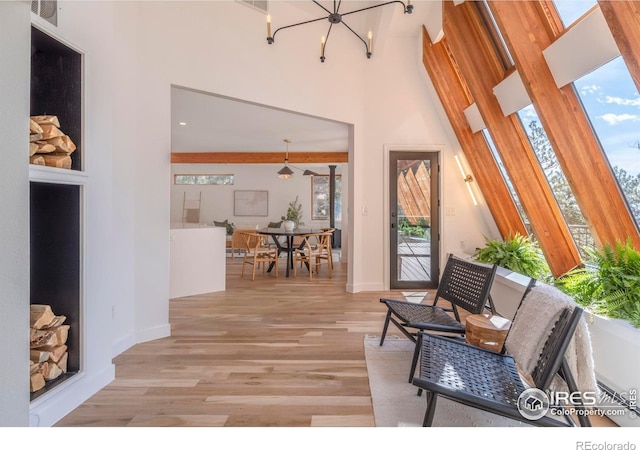 interior space featuring light hardwood / wood-style flooring, a healthy amount of sunlight, and a high ceiling