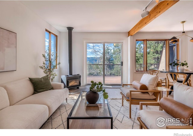 living room with beam ceiling and a wood stove