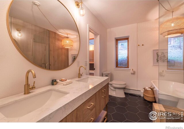 bathroom featuring a baseboard radiator, a tub, toilet, vanity, and tile patterned flooring