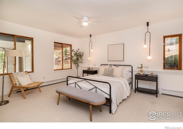 bedroom featuring a baseboard heating unit, light carpet, and ceiling fan