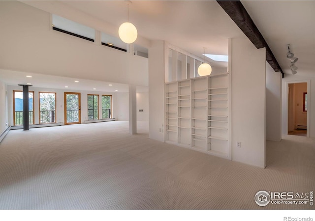 interior space with beam ceiling, a high ceiling, and a baseboard heating unit