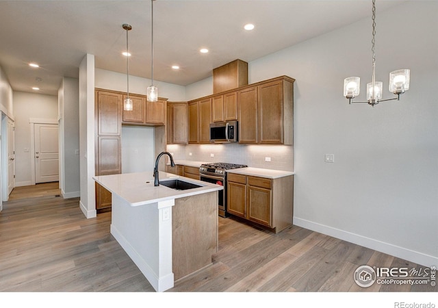 kitchen featuring light hardwood / wood-style flooring, a center island with sink, stainless steel appliances, and sink