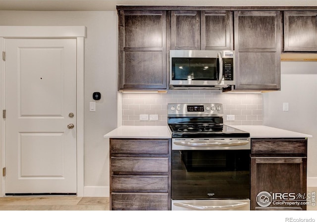 kitchen featuring decorative backsplash, appliances with stainless steel finishes, light hardwood / wood-style flooring, and dark brown cabinets