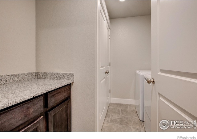 clothes washing area featuring light tile patterned flooring and separate washer and dryer