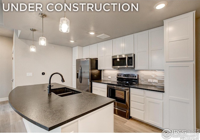 kitchen with sink, white cabinets, hanging light fixtures, and stainless steel appliances