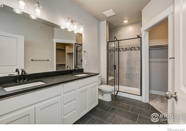 bathroom featuring vanity, toilet, tile patterned floors, and an enclosed shower